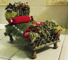 an old fashioned bench is covered with plants and other things to decorate it for the holiday season