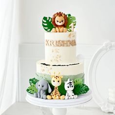 a three tiered cake decorated with jungle animals