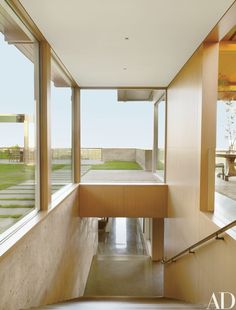 the inside of a house with large windows and stairs leading up to an outside deck