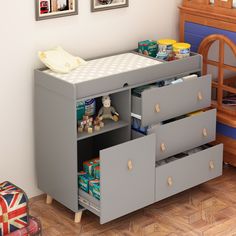 a child's changing table with drawers and toys