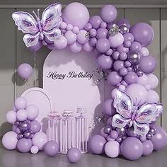 a purple birthday party with balloons and butterflies on the front door, along with decorations