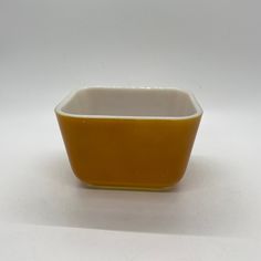 a yellow and white bowl sitting on top of a table