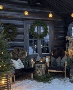 a log cabin decorated for christmas with wreaths and lights