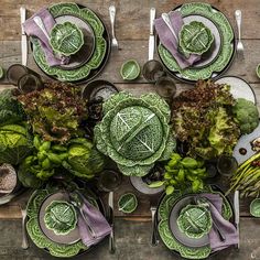 an overhead view of a table set with green plates and silverware, including lettuce