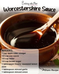 a wooden bowl filled with black sauce next to a spoon on top of a table