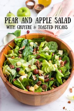 a wooden bowl filled with lettuce, grapes and toasted pecans on top of a marble counter