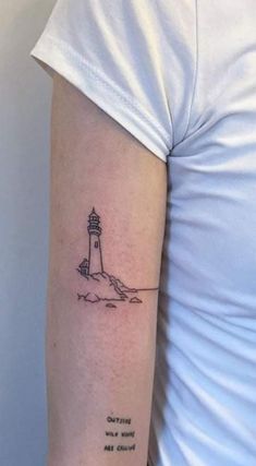 a woman with a small lighthouse tattoo on her arm