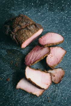 slices of meat sitting on top of a cutting board