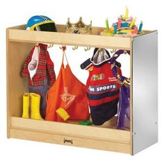 a wooden cubby with sports gear on the top and clothes hanging from it's sides