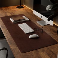 a computer desk with a mouse, keyboard and glasses on it in front of a monitor