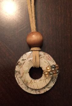 a wooden bead hanging from a string on top of a wood table next to a wall