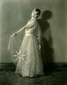 an old photo of a woman in a dress with flowers on the skirt and veil