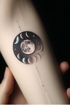 a person with a tattoo on their arm that has phases of the moon and stars