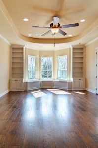 an empty room with wooden floors and ceiling fan in it's centerpieces