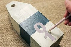 a person is holding a pencil in front of a wooden box