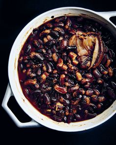 a pot filled with beans and onions on top of a table