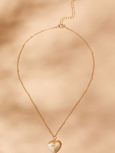 Cherish your memories with our heart-shaped locket necklace. It has vintage charm with its antique finish. This timeless piece features a delicate frame, ready to hold your cherished photo close to your heart. Elegant Antique Gold Heart Pendant Necklaces, Antique Gold Heart Pendant Necklace For Valentine's Day, Antique Gold Necklace With Heart Charm For Valentine's Day, Antique Gold Necklace With Heart Charm, Antique Gold Necklace With Heart Pendant, Antique Gold Heart Necklace With Vintage Charm, Antique Gold Engraved Heart Pendant Necklace, Heart Shaped Locket, Gold Heart Locket