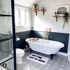 a white bath tub sitting inside of a bathroom next to a toilet