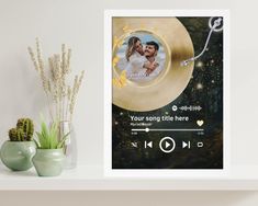 a photo frame with an image of a couple on it next to a potted plant