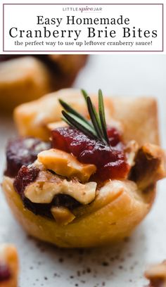 homemade cranberry brie bites with rosemary garnish on top and text overlay that reads, easy homemade cranberry brie bites