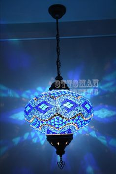 a chandelier hanging from the ceiling in a room with blue light coming through it