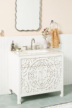 a white sink sitting under a mirror next to a tiled floor in a room with pink walls