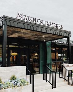 the front entrance of a restaurant with stairs leading up to it