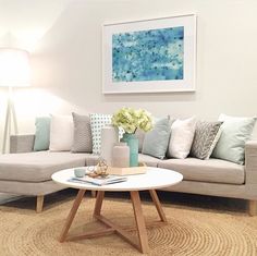 a living room filled with furniture and a painting on the wall above it's coffee table