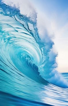 a large blue wave in the ocean on a sunny day