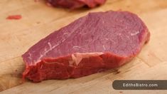 a piece of meat sitting on top of a wooden cutting board