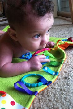 a baby laying on top of a green blanket