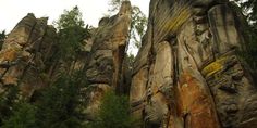 some very tall rocks with trees in the background