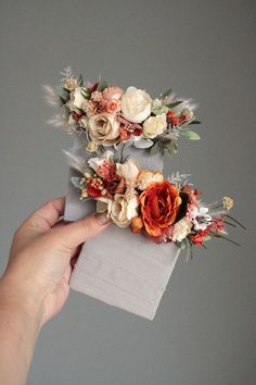 someone is holding some flowers on top of a piece of paper