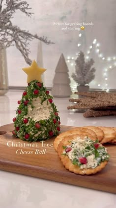 a wooden cutting board topped with crackers and a christmas tree decoration on top of it