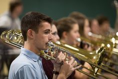 a man is playing the trumpet in front of other people