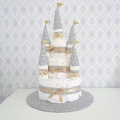 a diaper cake is decorated with gold bows and trees on it's side