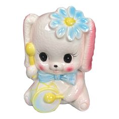 a little white bear figurine with a blue flower on it's head