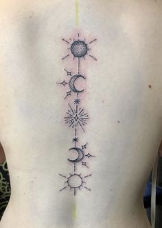 the back of a woman's lower back tattoo with sun, moon and stars