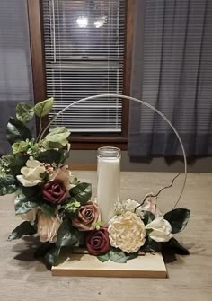 an arrangement of flowers and candles on a table