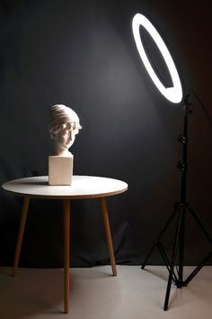 a light that is on top of a table next to a busturine head