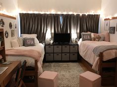 two twin beds in a bedroom with lights on the ceiling and windows above them,