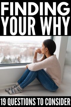 a woman sitting in front of a window with her hand on her chin looking out the window