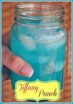 a person holding a blue mason jar with ice in it and the caption tiffany punch just 2 ingredients and tastes like a jolly ranch mix one part