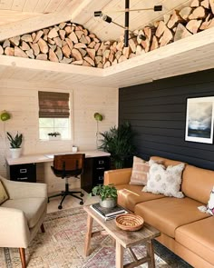 a living room filled with furniture and lots of firewood stacked on the wall above it