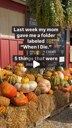 hay bales filled with pumpkins and gourds in front of a store