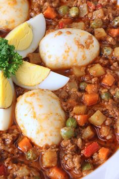 some kind of food in a bowl with eggs and other things on top of it