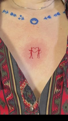 a woman with tattoos on her chest has a heart and two arrows in the middle