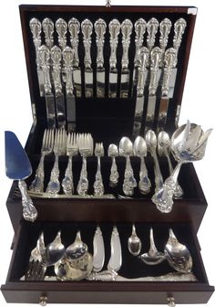 an assortment of silverware in a wooden box with spoons and forks on display