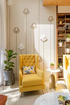 a yellow chair sitting next to a white table in a living room filled with furniture