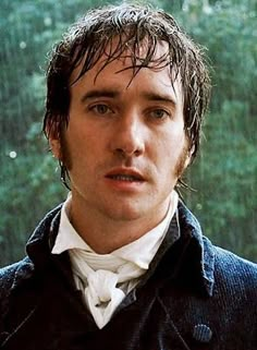 a man with wet hair standing in the rain